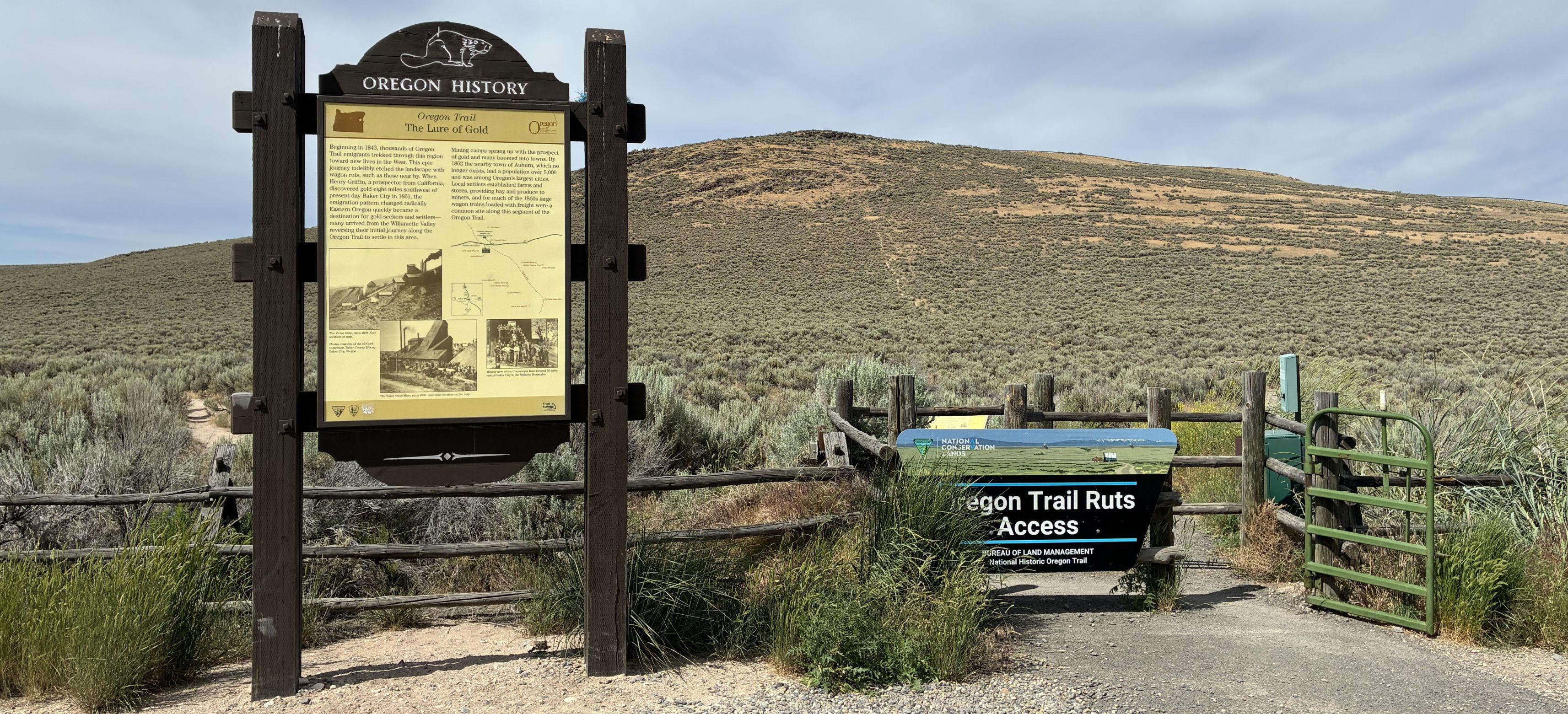 Wooden sign with hill in background and federal land sign to right. 