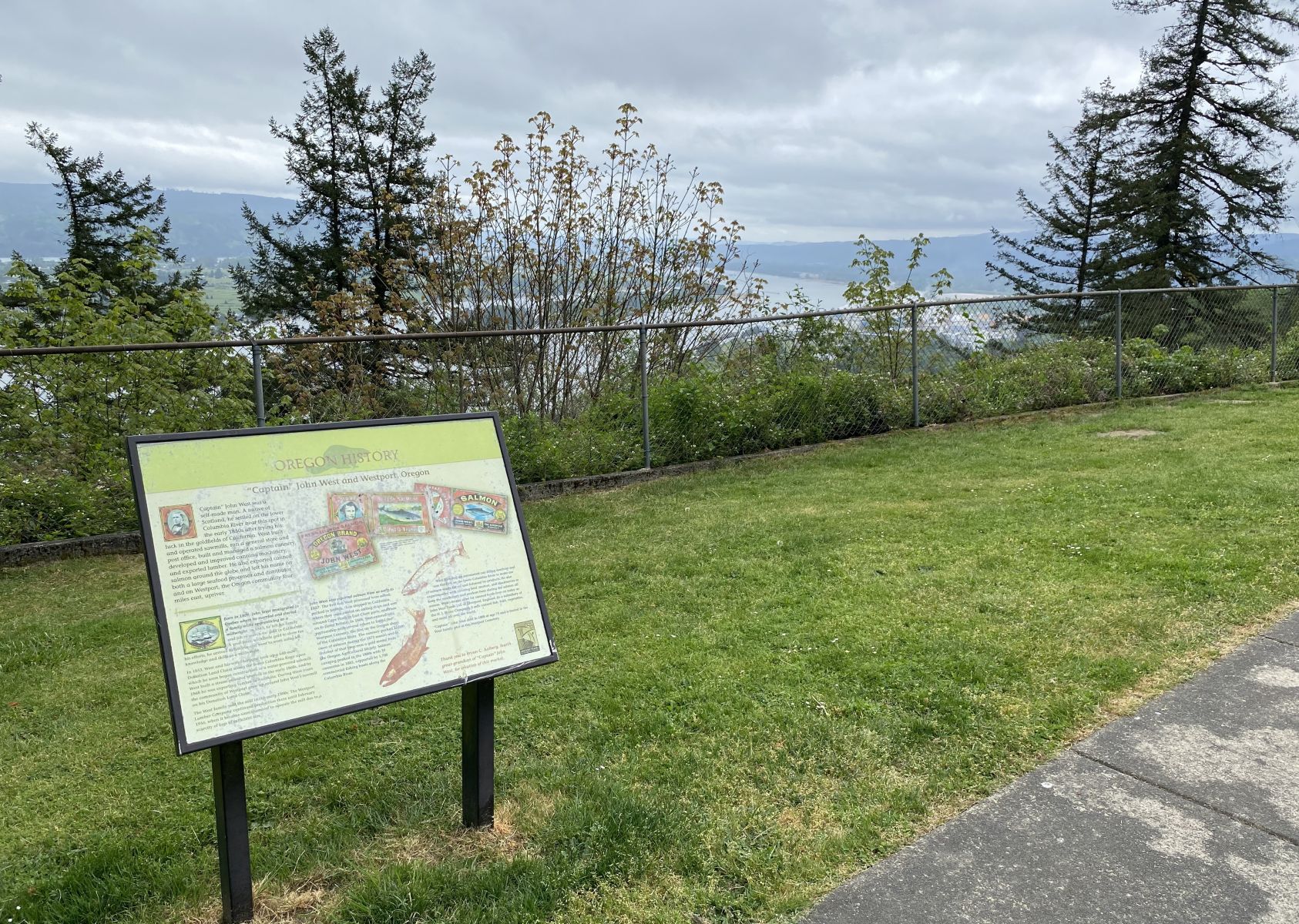 Image of park overlooking the Columbia River on a cloudy day with historical sign in lower left corner.
